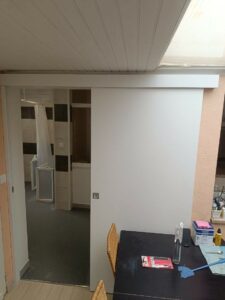 Porte coulissante installée dans salle de bains PMR à Maing